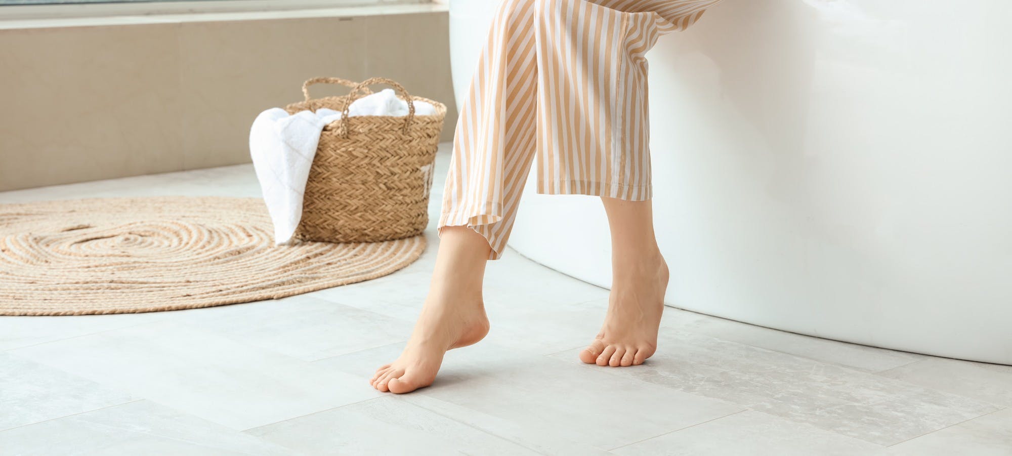 Vrouw in pyjama zit op de rand van het bad